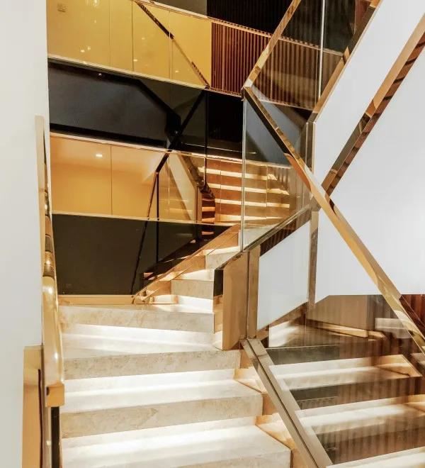 Beige Marble Staircase With Gold Metal Handrail
